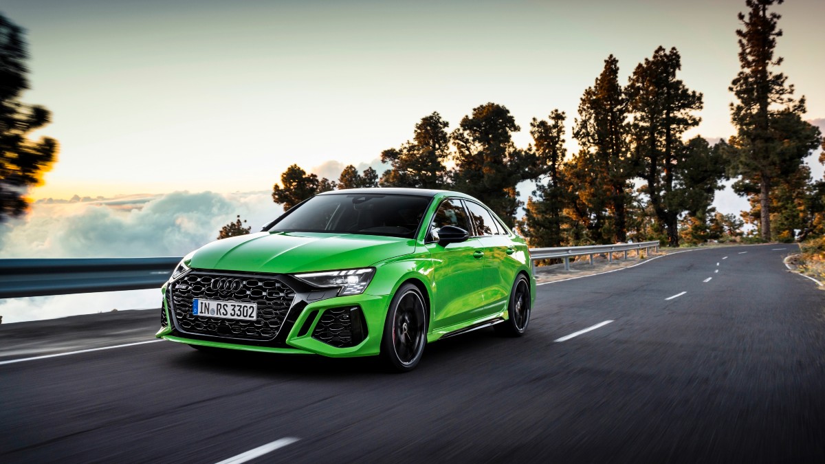 a green 2022 audi rs3 driving on road displaying its performance prowess