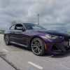 The front 3/4 view of a purple 2022 BMW M240i xDrive Coupe on Road America's autocross course