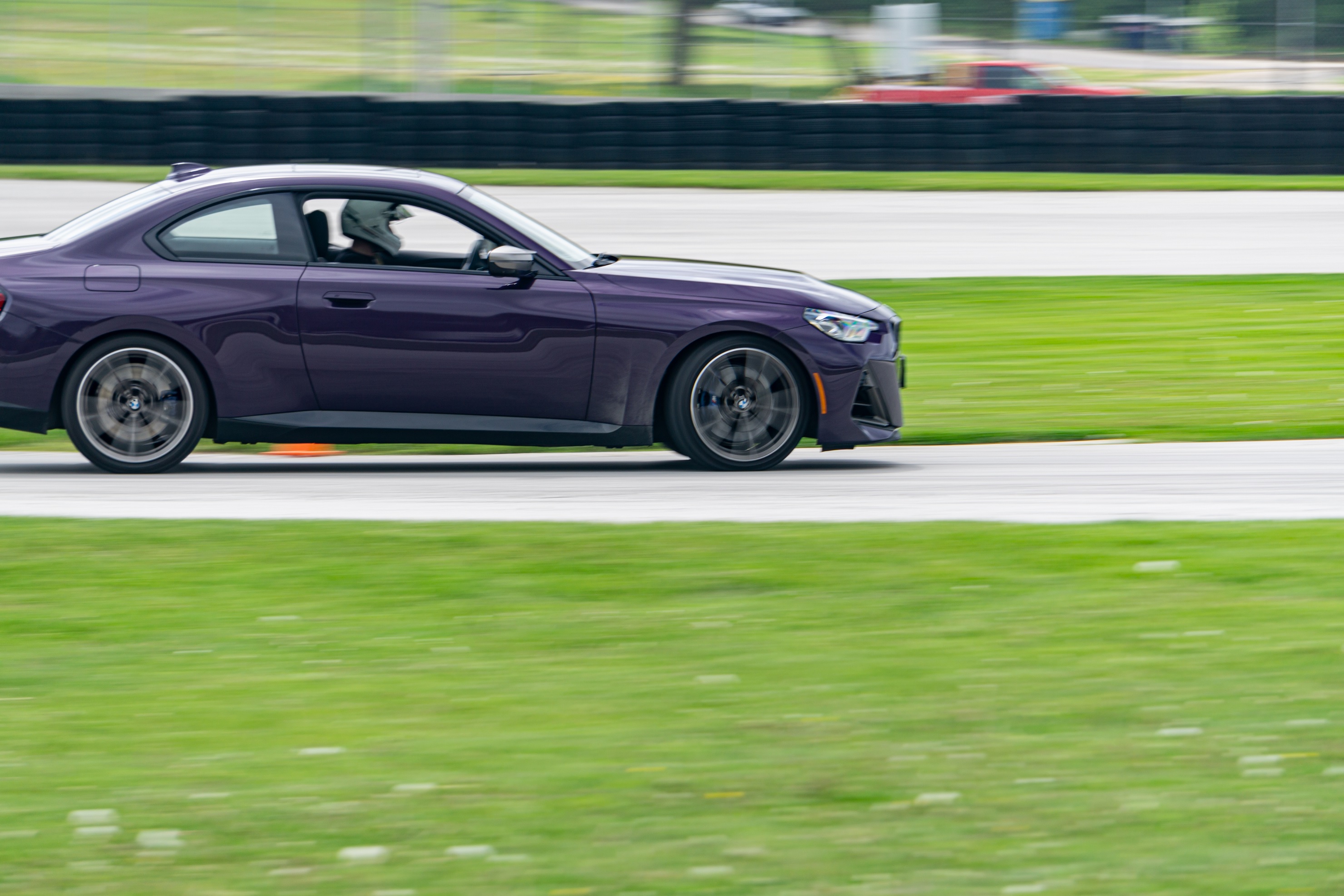 A close-up view of a purple 2022 BMW M240i xDrive Coupe racing around Road America's autocross course