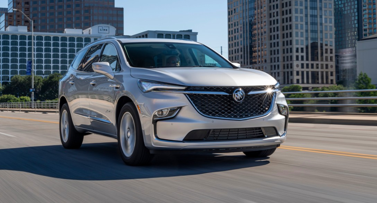 A gray Buick Enclave is driving on the road.