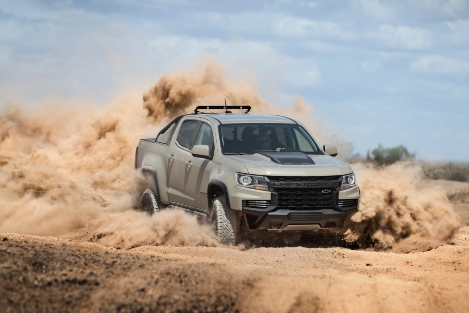 A Chevrolet Colorado midsize truck drives through the desert sand.