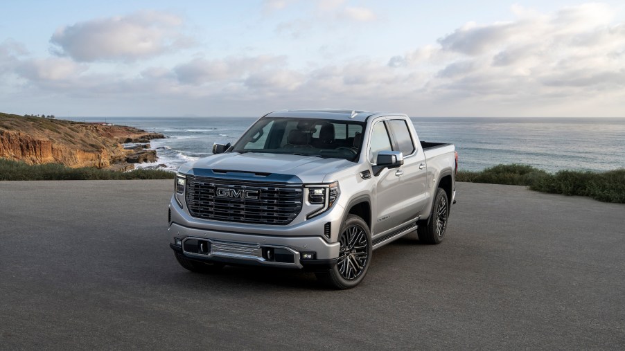 A silver 2022 GMC Sierra parked in front of the ocean.