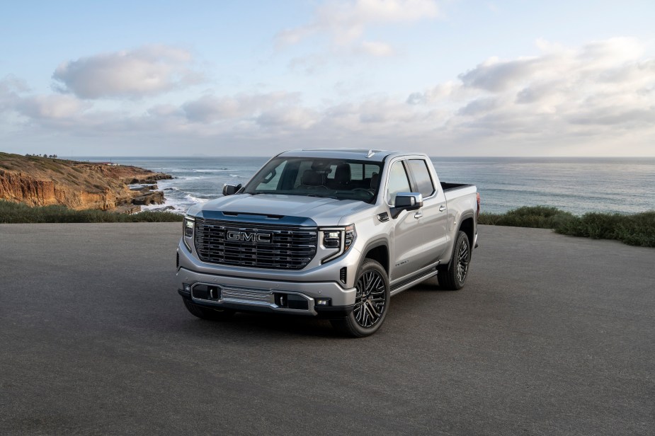 A silver 2022 GMC Sierra parked in front of the ocean.