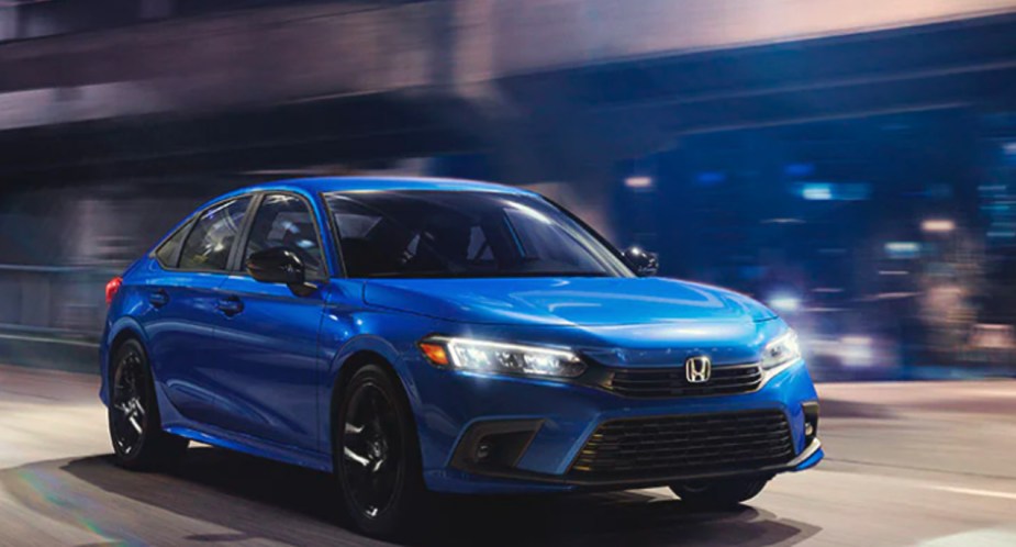 A blue 2022 Honda Civic sedan is driving on the road. 