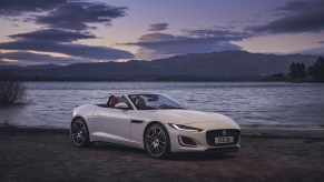 A white 2022 Jaguar F-Type Convertible P450 in front of a body of water with its roof down
