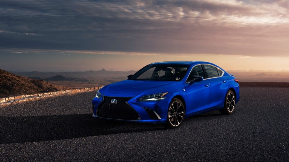 blue lexus 2022 is parked with a sunset behind it