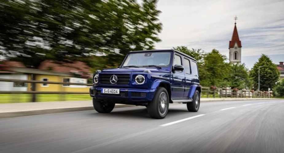 A blue 2022 Mercedes-Benz G-Class is driving on the road. 
