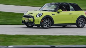 A yellow-green 2022 Mini Cooper S Convertible cornering around Road America's autocross course