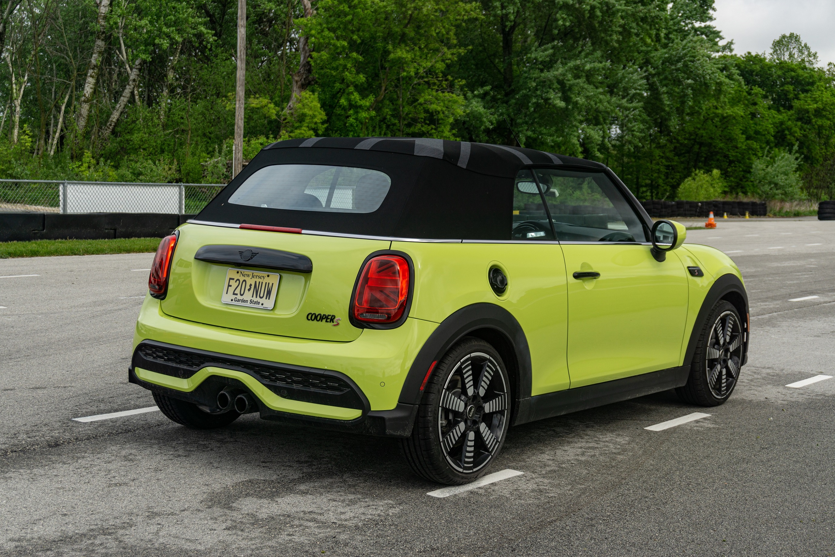 The rear 3/4 view of a yellow-green 2022 Mini Cooper S Convertible on Road America's autocross course