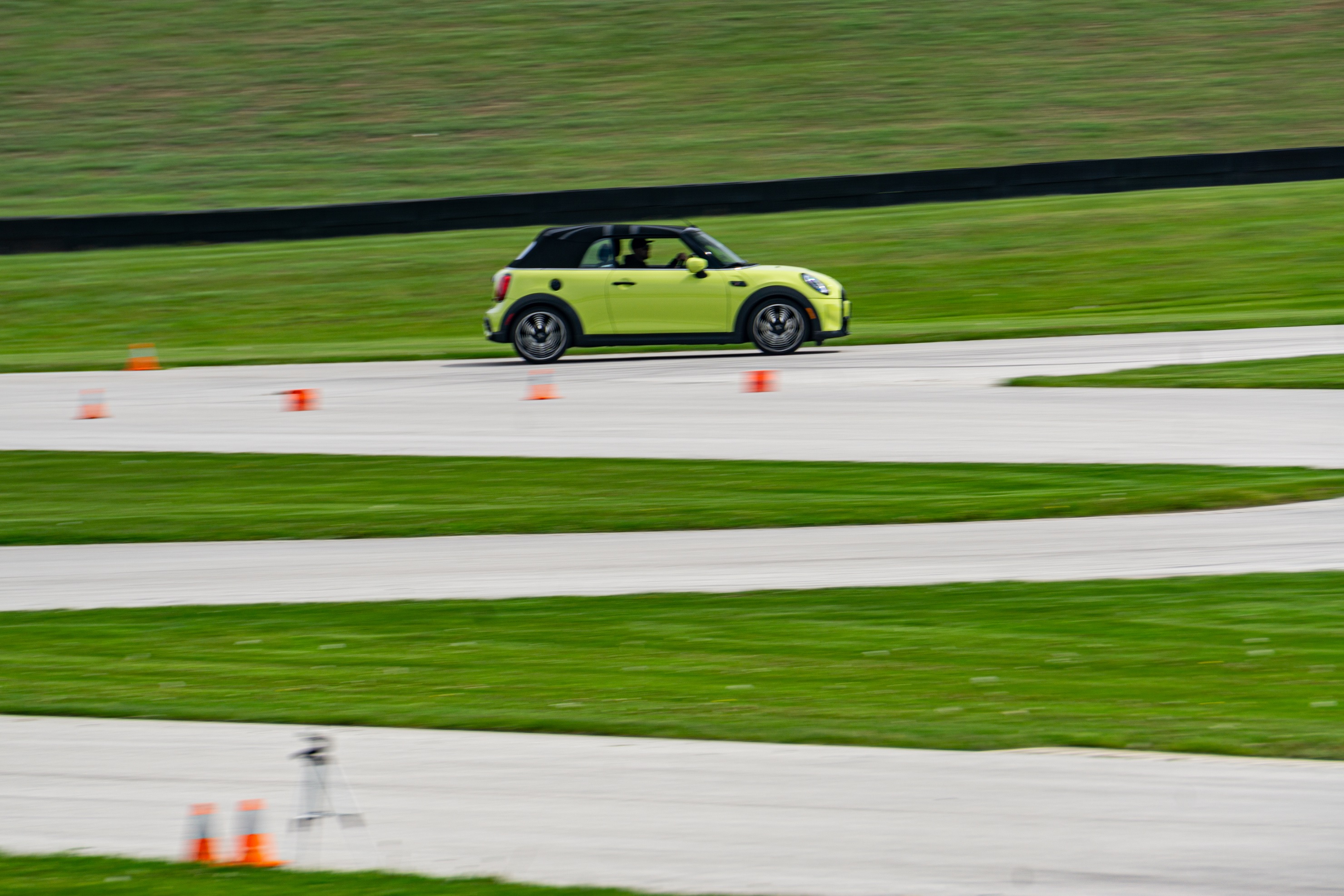 The side view of a yellow-green 2022 Mini Cooper S Convertible racing on Road America's autocross course