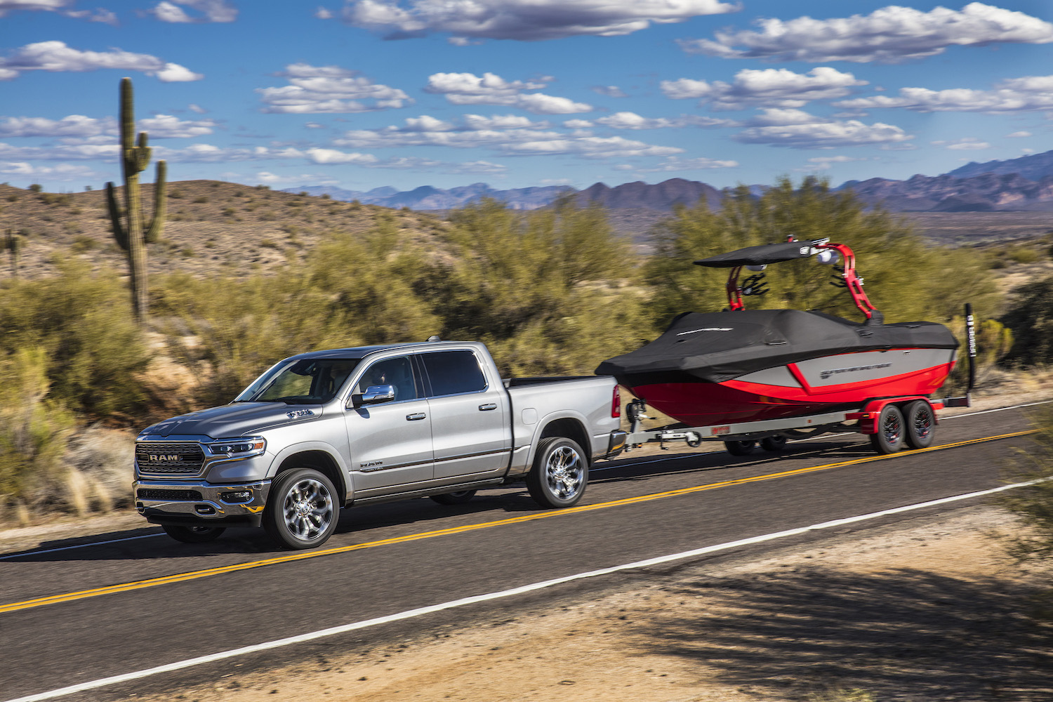A silver 2022 Ram 1500 towing a boat.