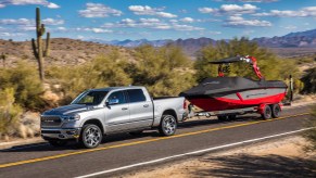 A silver 2022 Ram 1500 towing a boat.