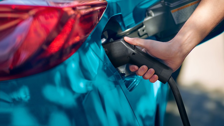 User plugging an EV charger into a 2022 Toyota Prius Prime Plug-in Hybrid