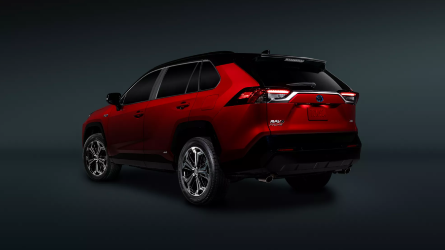 A promotional shot of a red 2022 Toyota RAV4 Prime plug-in hybrid electric vehicle (PHEV) side and rear