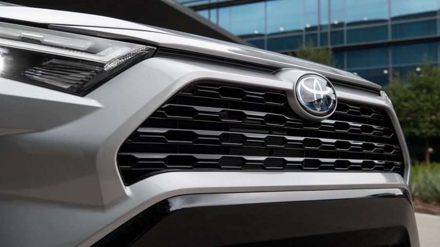 A front photo of the headlights, badging, and grille of a 2022 Toyota RAV4 Hybrid SE compact crossover SUV