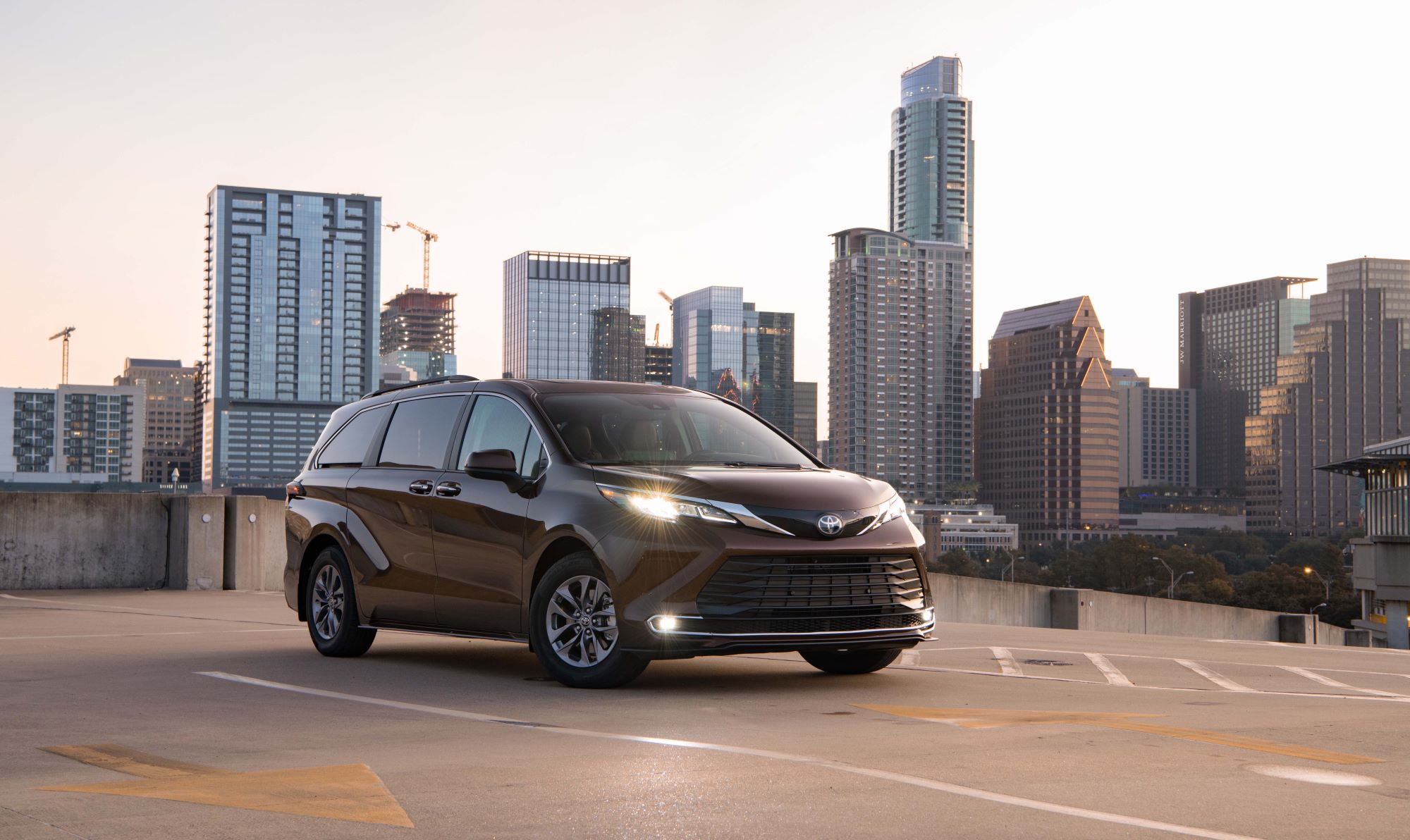 A black 2022 Toyota Sienna in front of a city skyline.