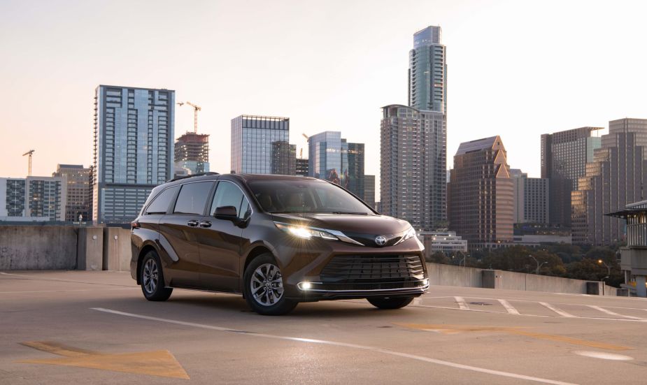 A dark colored 2022 Toyota Sienna in front of a city skyline.