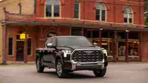 A dark colored 2022 Toyota Tundra in front of a building.