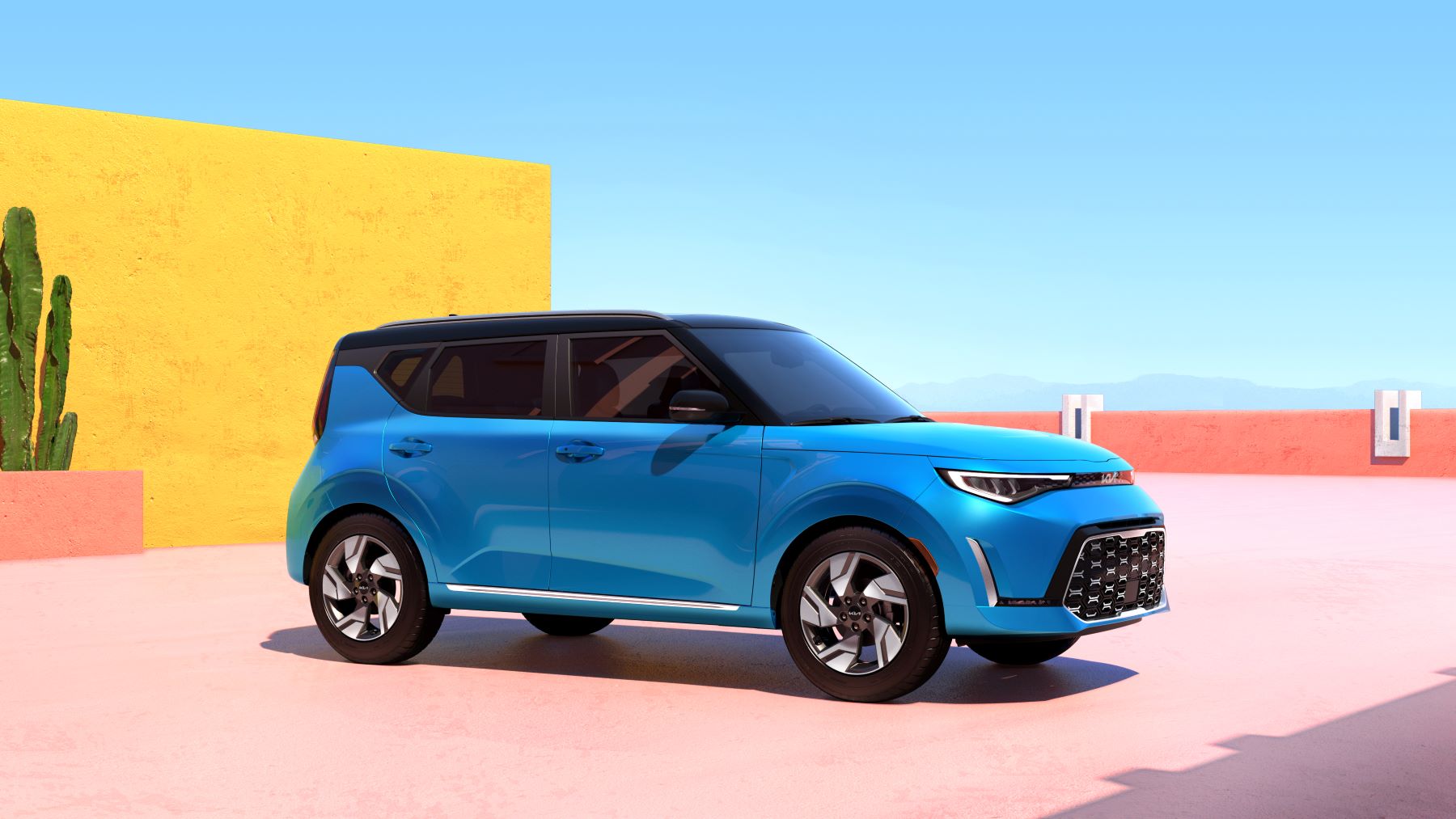 A light blue 2023 Kia Soul subcompact crossover SUV model parked in a desert location on a pink plaza near a cactus