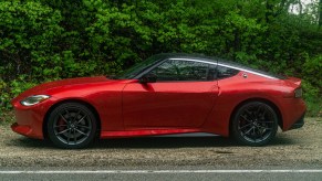 The side view of a red 2023 Nissan Z Performance in a forest