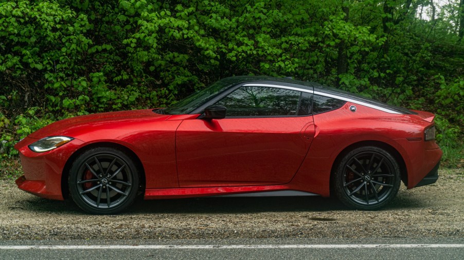 The side view of a red 2023 Nissan Z Performance in a forest