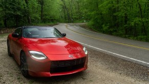 A red 2023 Nissan Z Performance by the side of a rainy forest road