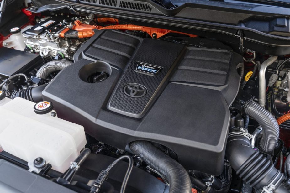 Closeup of a Toyota Sequoia SUV's engine bay with i-FORCE MAX hybrid engine visible.