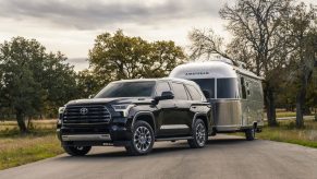 2023 Toyota Sequoia SUV parked in front of an airstream camper trailer.