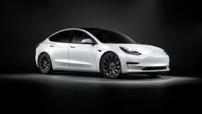 White Tesla Model 3 luxury electric car set against a dark background