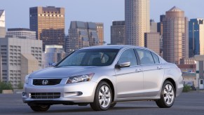 A silver 8th-gen 2008 Honda Accord EX-L V6 parked in front of a city skyline