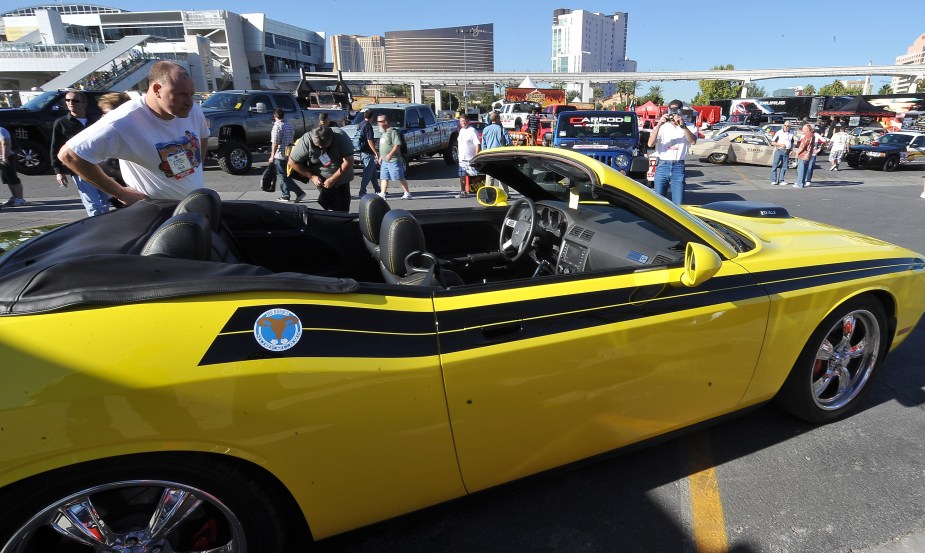 A yellow-with-black-stripes custom 2010 Dodge Challenger convertible in the SEMA 2009 parking lot