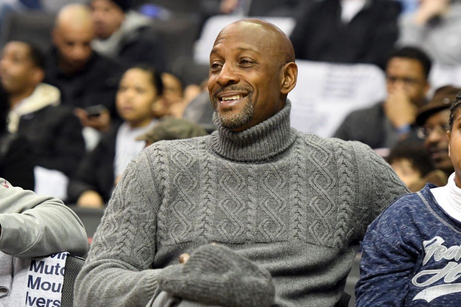 Alonzo Mourning, who visited a Pontiac dealership, wearing a gray sweater while sitting in a crowd. 