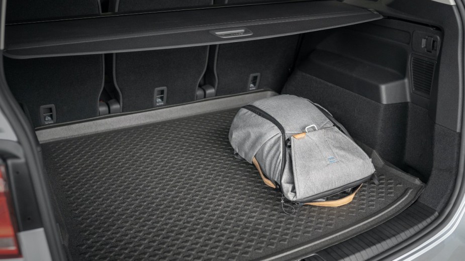 a backpack in the trunk of a car, carry less cargo to extend the range of your ev
