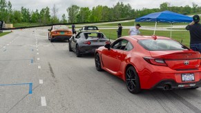 A 2022 Toyota GR86, Mazda MX-5 Miata RF, Subaru WRX, and Mini Cooper S Convertible lined up on Road America's go-kart track for autocross racing
