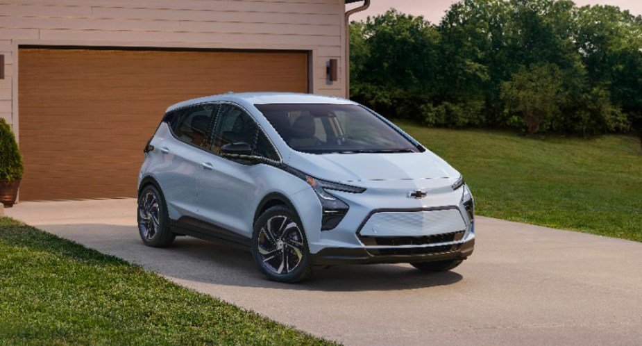 A blue 2023 Chevy Bolt EV is parked in a driveway. 