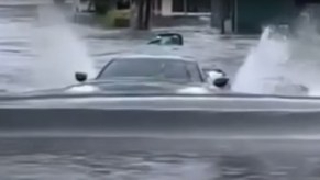 Chevy C8 Corvette drives through water like a submarine on a flooded street in Florida