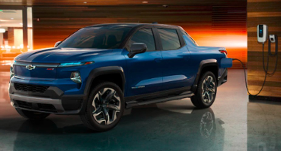 A blue 2024 Chevy Silverado EV RST is charging. 