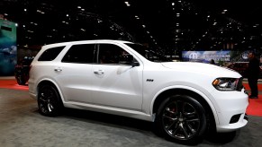 A white Dodge Durango a muscle car parked indoors.