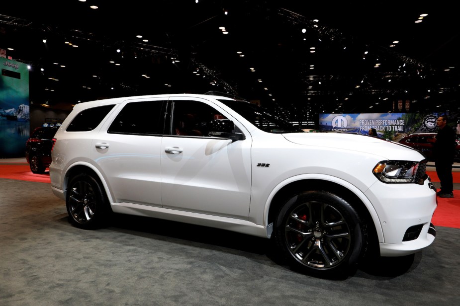 A white Dodge Durango a muscle car parked indoors.