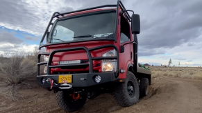 A red EarthCruiser CORE driving off-road