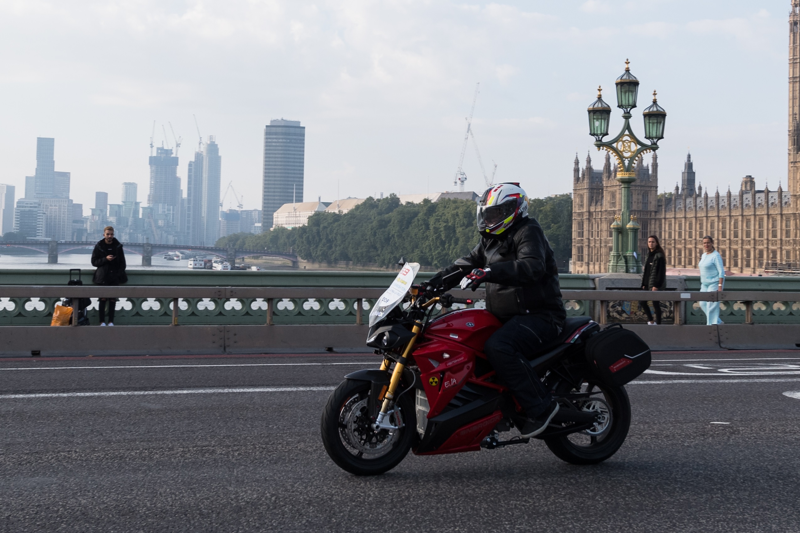 A black-clad rider on a red Energica Eva Ribelle riding in the 2021 London to Brighton Electric Vehicle Rally