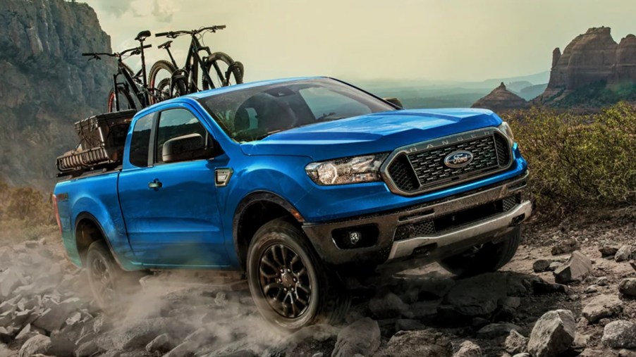A blue 2022 Ford Ranger midsize pickup truck is driving off-road.