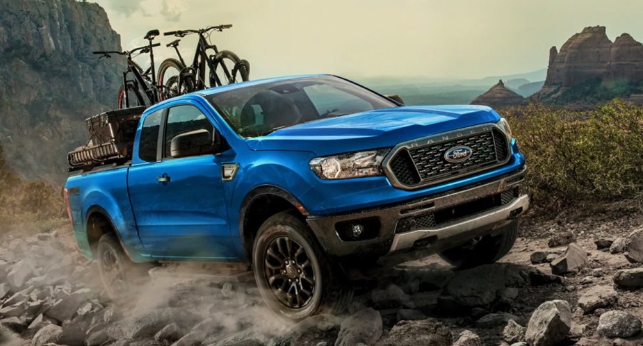 A blue 2022 Ford Ranger midsize pickup truck is driving off-road.