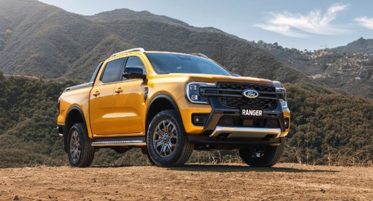 A yellow 2023 Ford Ranger Wildtrak small pickup truck is parked outdoors. 