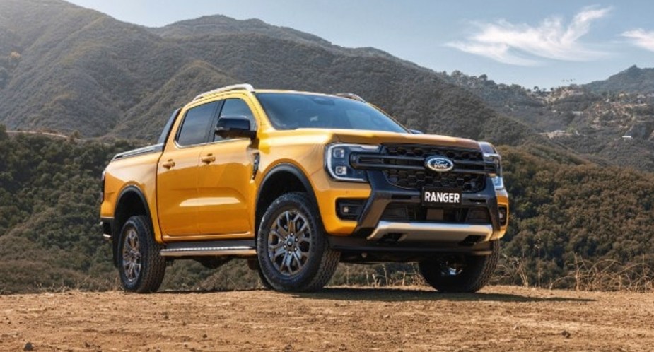 A yellow Ford Ranger Wildtrak small pickup truck is parked outdoors.