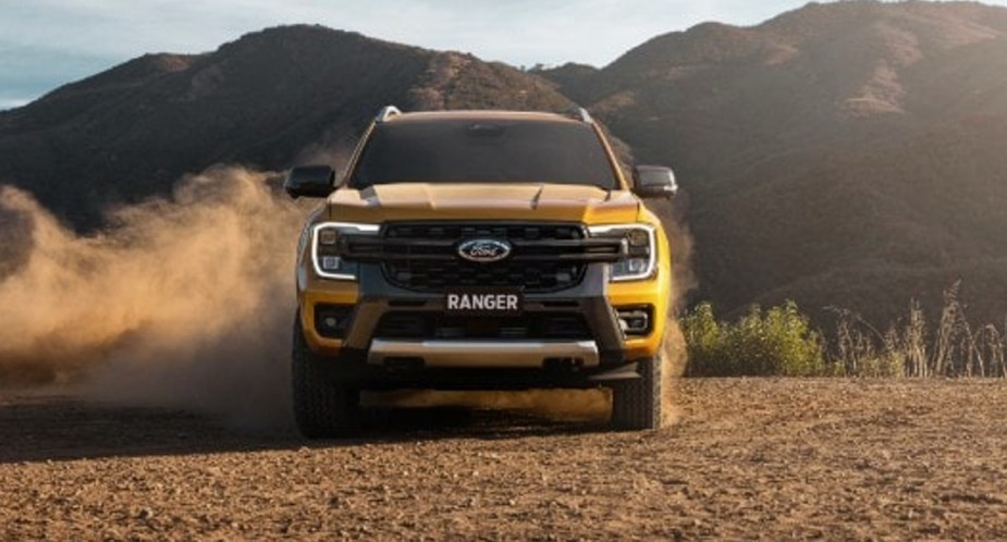 A yellow 2023 Ford Ranger Wildtrak small pickup truck is parked outside. 