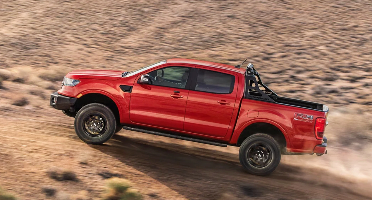 A red 2022 Ford Ranger midsize pickup truck is driving off-road.