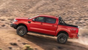 A red 2022 Ford Ranger midsize pickup truck is driving off-road.