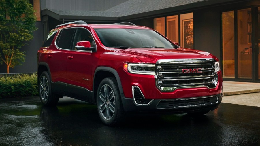 Front angle view or red 2023 GMC Acadia, highlighting its release date and price