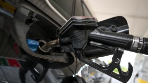 A black gas nozzle pumping gas as gas prices continue going up.